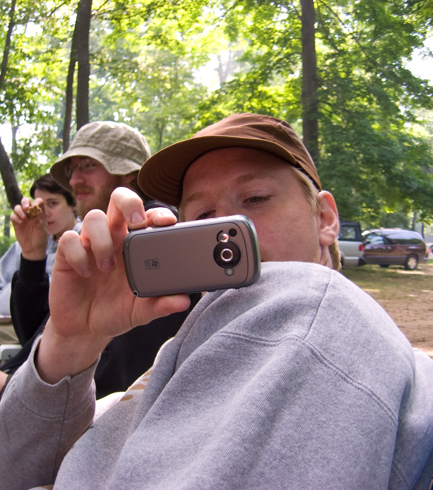 a person with his hands up, holding up a cellphone