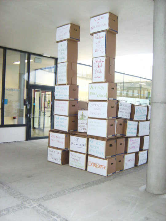 an arrangement of boxes stacked up outside of a building
