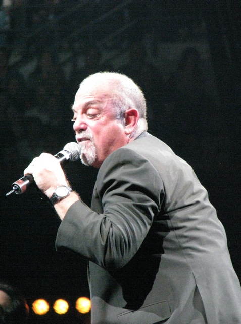 a man with a microphone sings into an audience