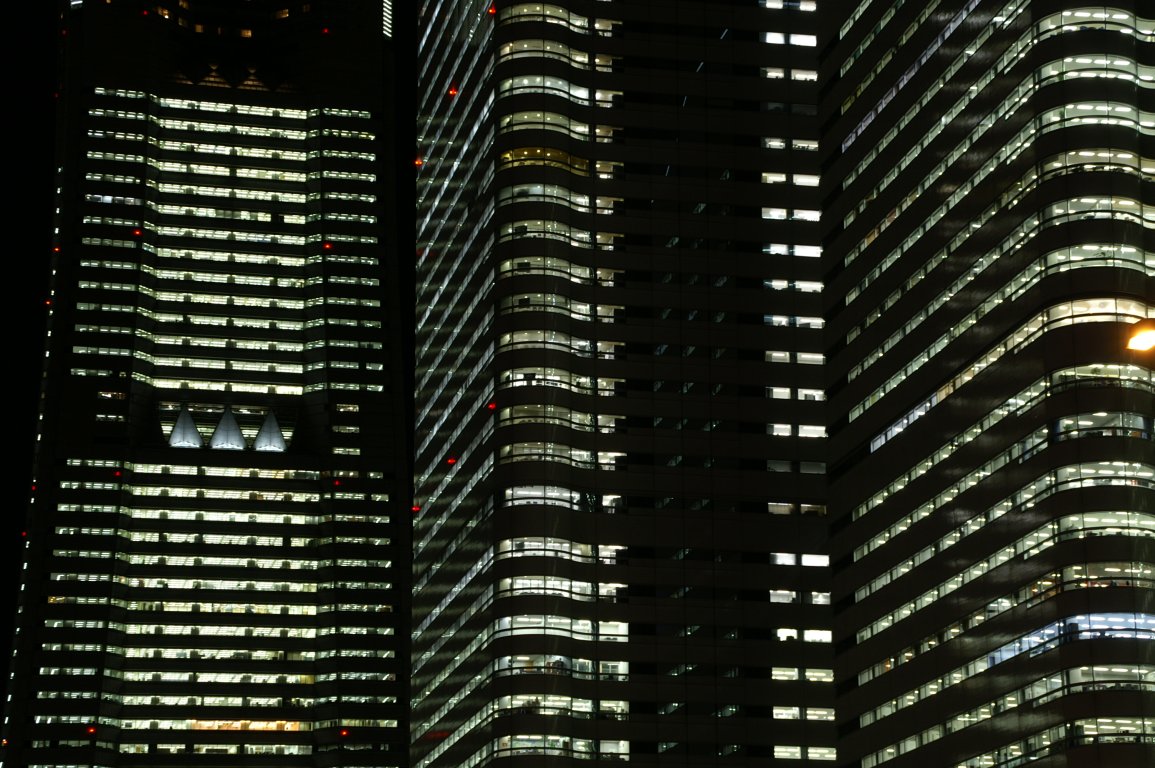 three buildings lit up with different lights at night