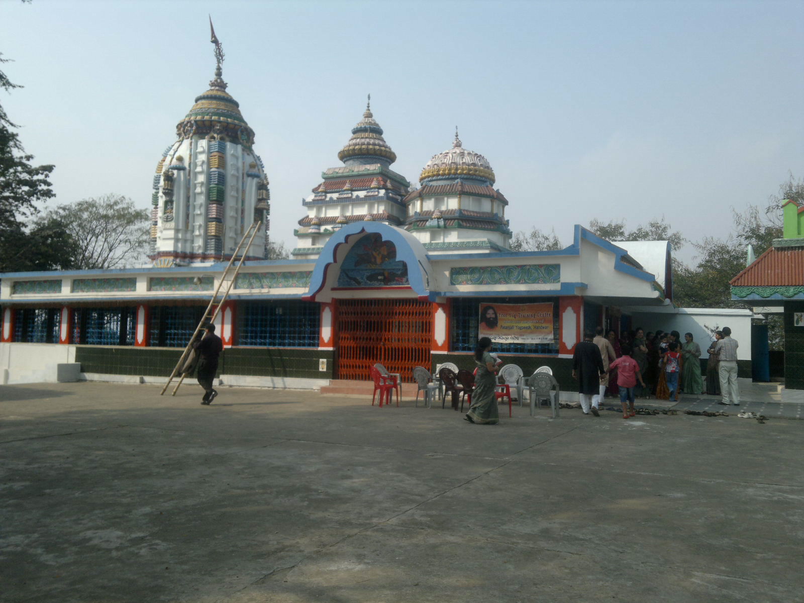 an indian temple with people standing and sitting