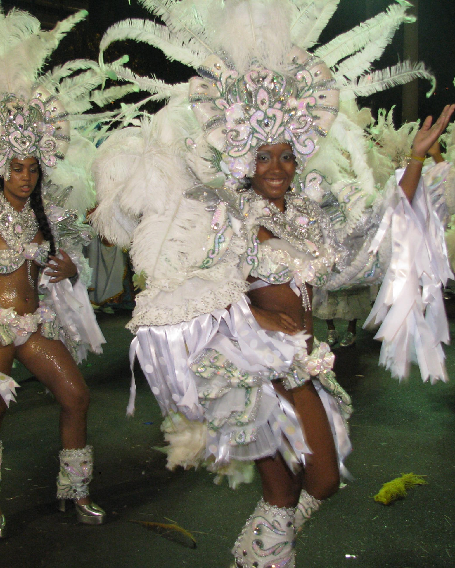 some people dance in their costumes and have white feathers