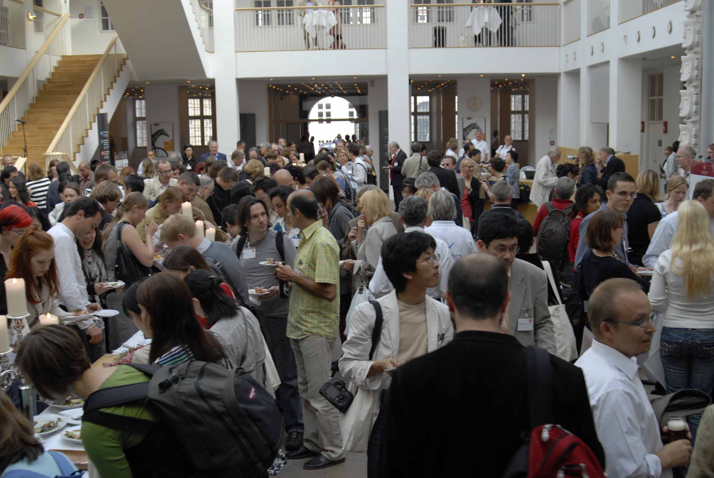 a large crowd in a lobby with the floor covered with people