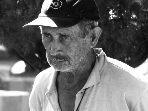 an older man wearing a hat and looking away