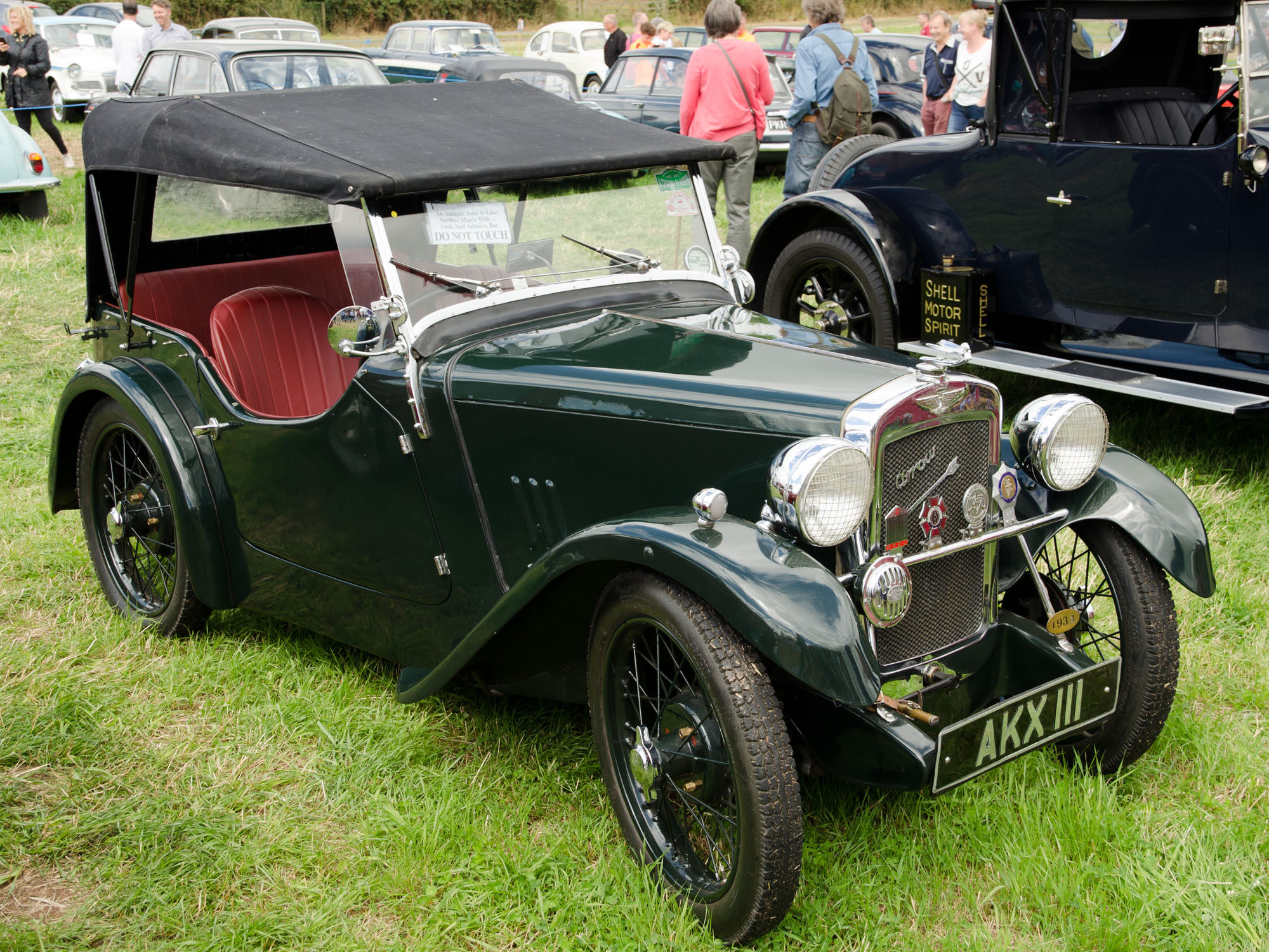 a vintage green car on display at an antique auto show