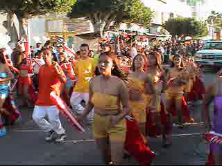 a parade with people dancing and carrying firecrots