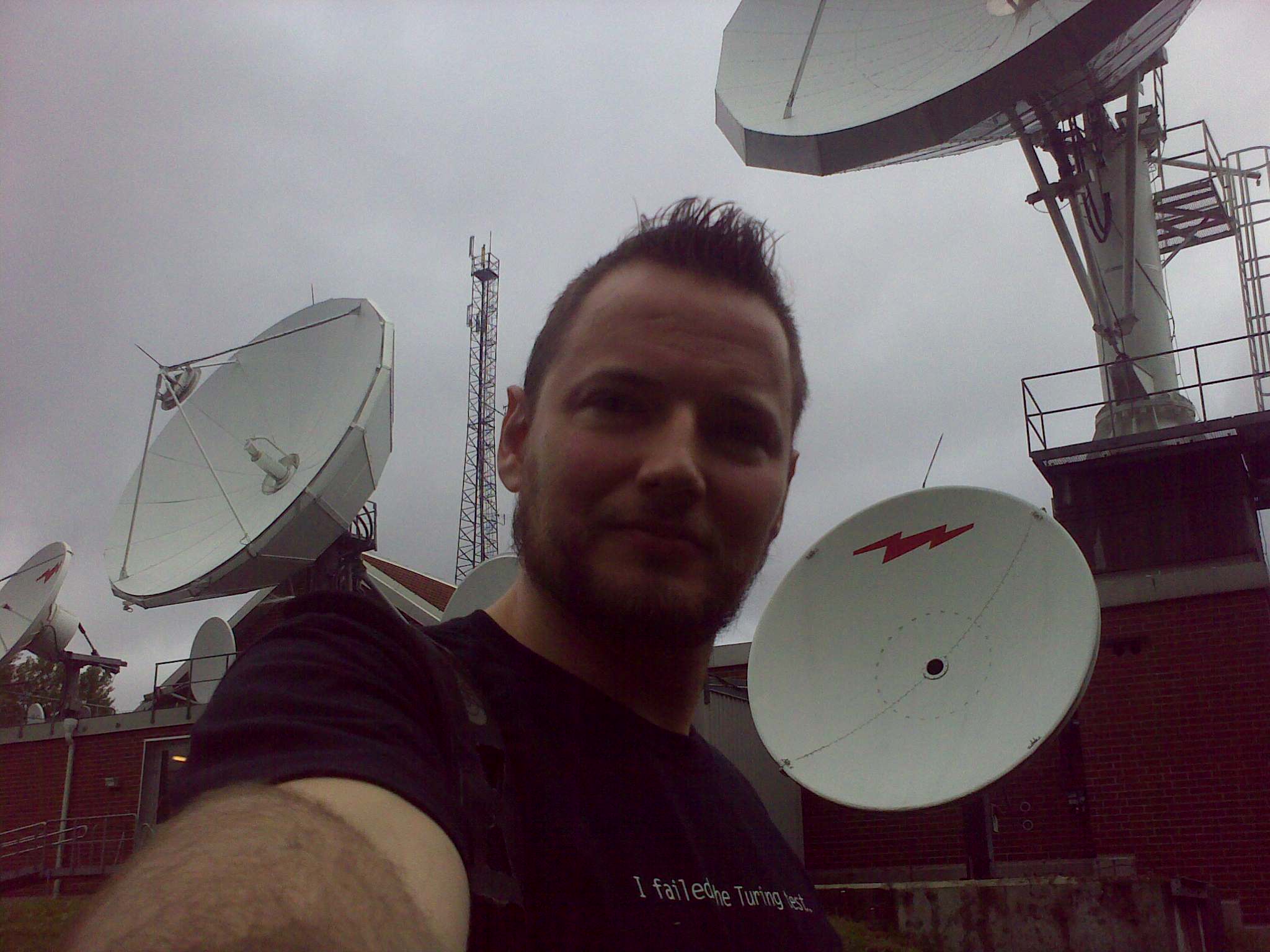 man in a black shirt holding several satellite dishes