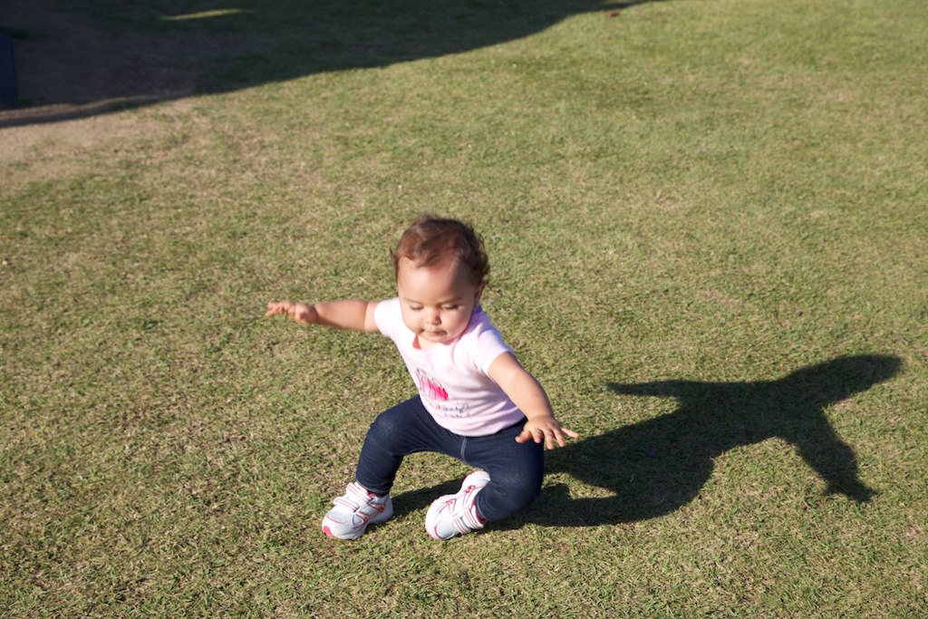 a baby sits on the grass in a field