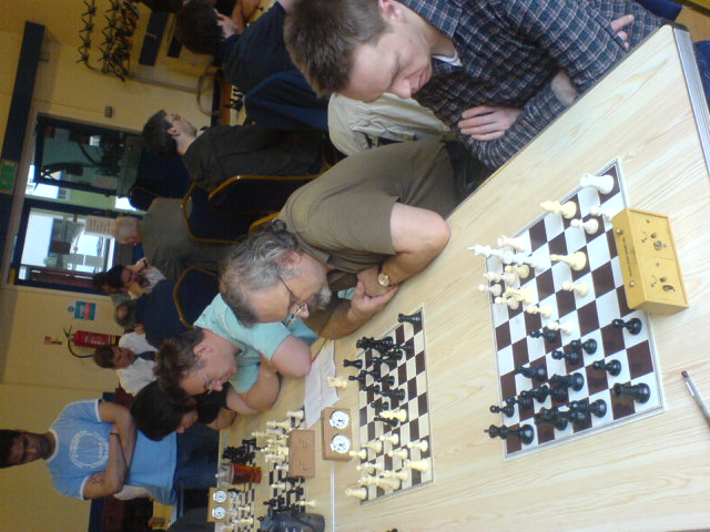 some people playing a game of chess on top of a table