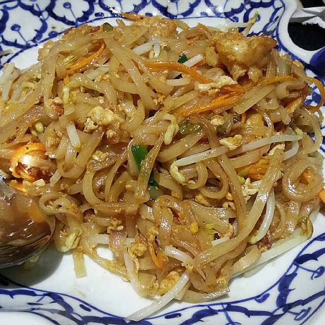 a white and blue plate with noodles, rice and onions