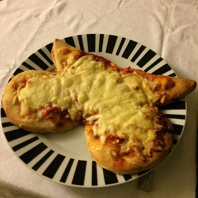 a plate with bread shaped like two pizzas