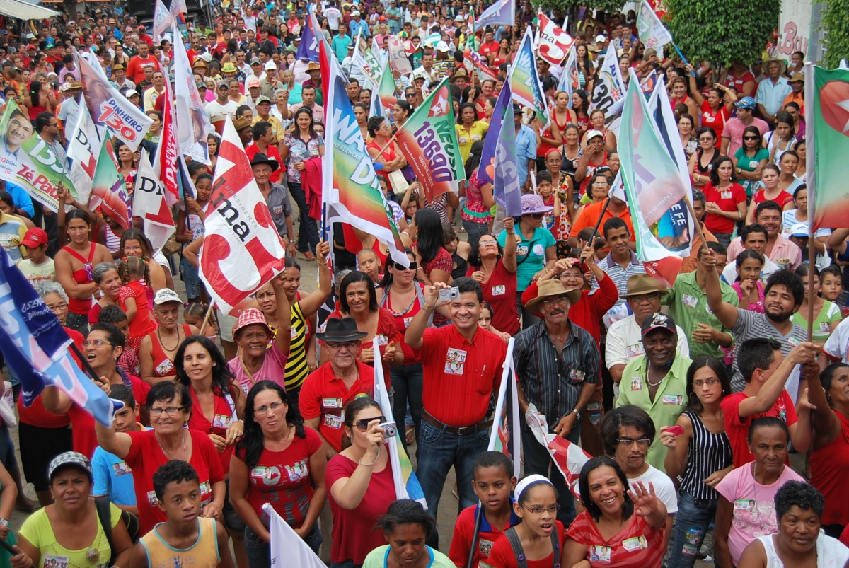 many people are standing on the street with flags