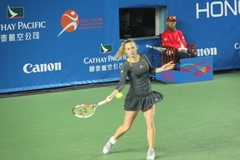 woman in short skirt holding a tennis racket