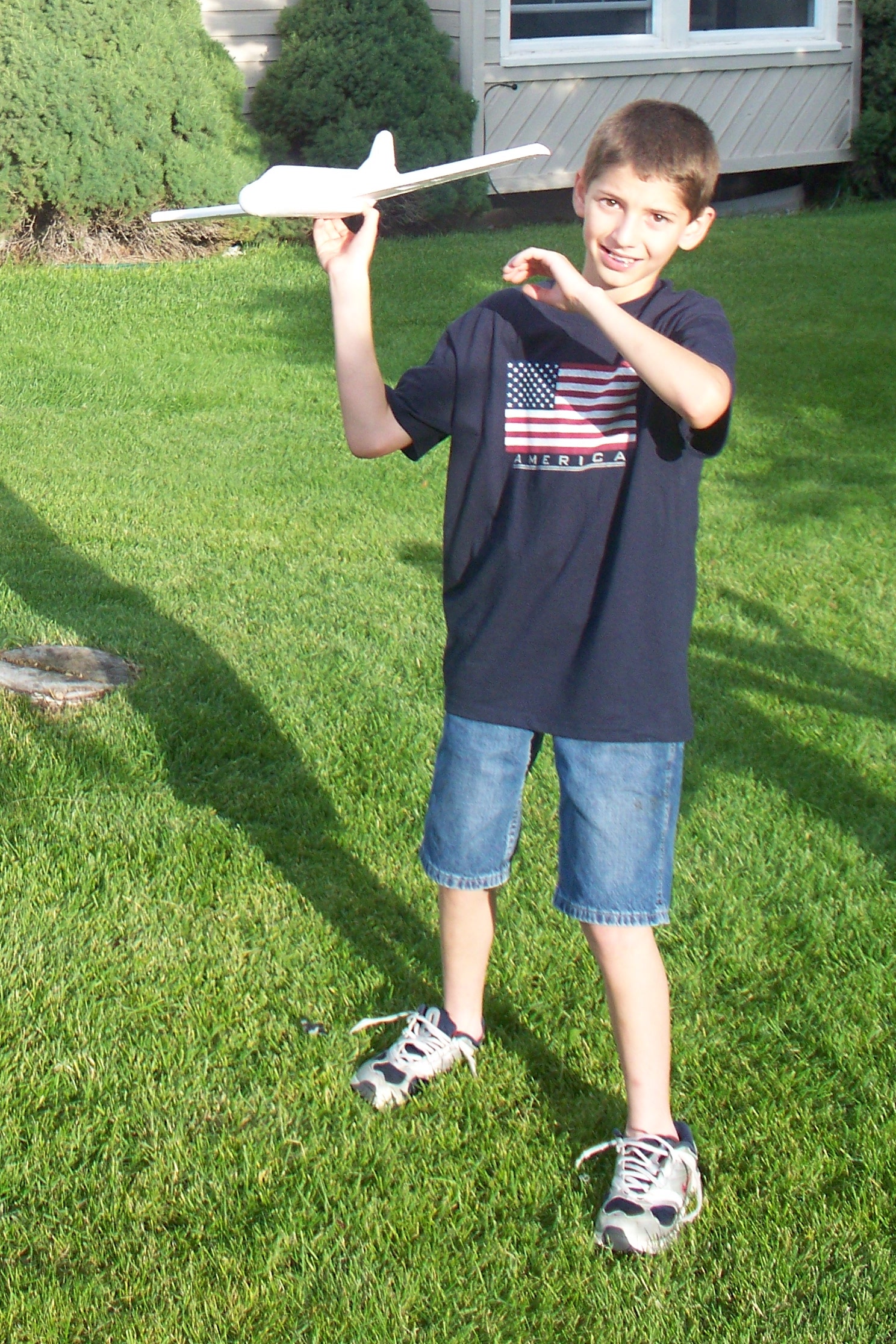 the boy is holding up a toy airplane