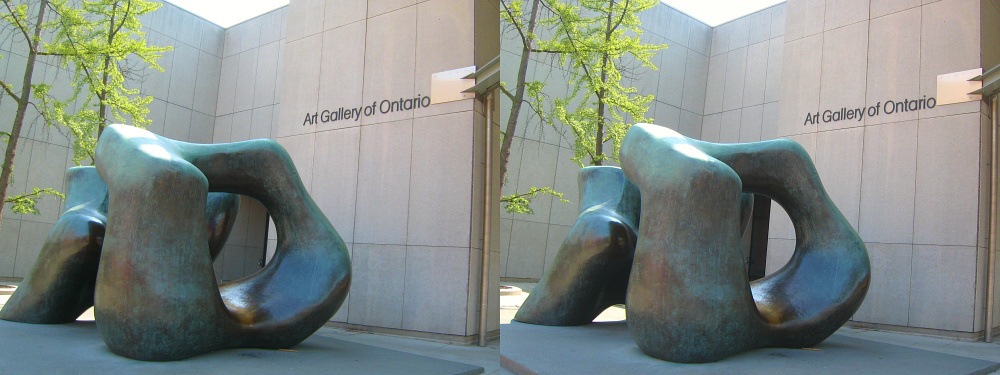 two sculpture in front of a building and a sign on the wall