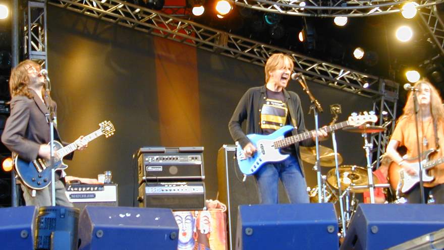 a band with blue guitars standing on a stage