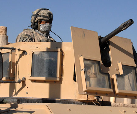 a man in a military gear sitting on top of a truck