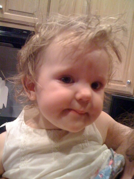 a toddler in the kitchen with a silly look