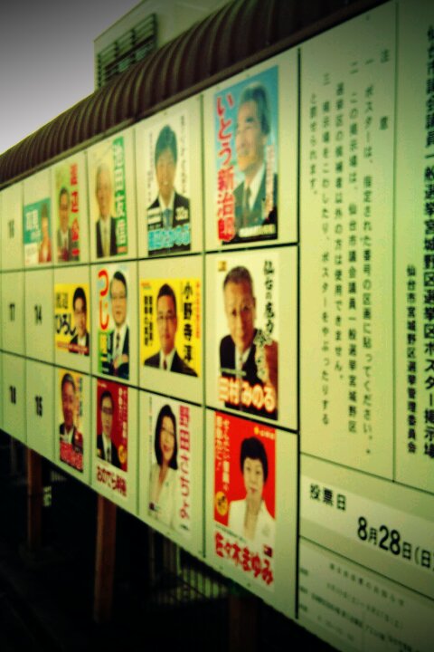 a poster outside a bus stop with many political images