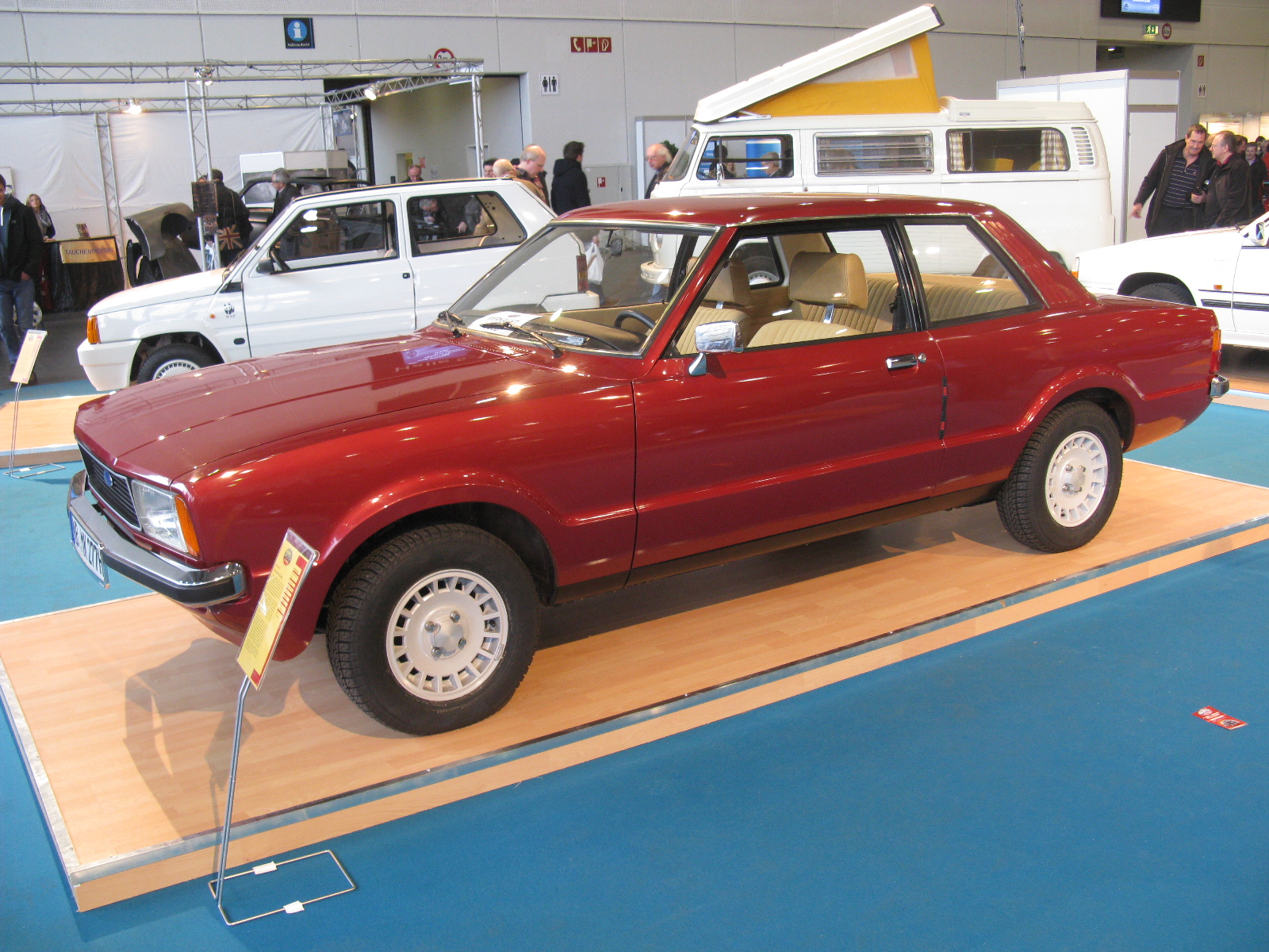 a maroon sports utility wagon on display at an automobile show