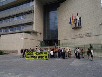a group of people holding signs in front of a building