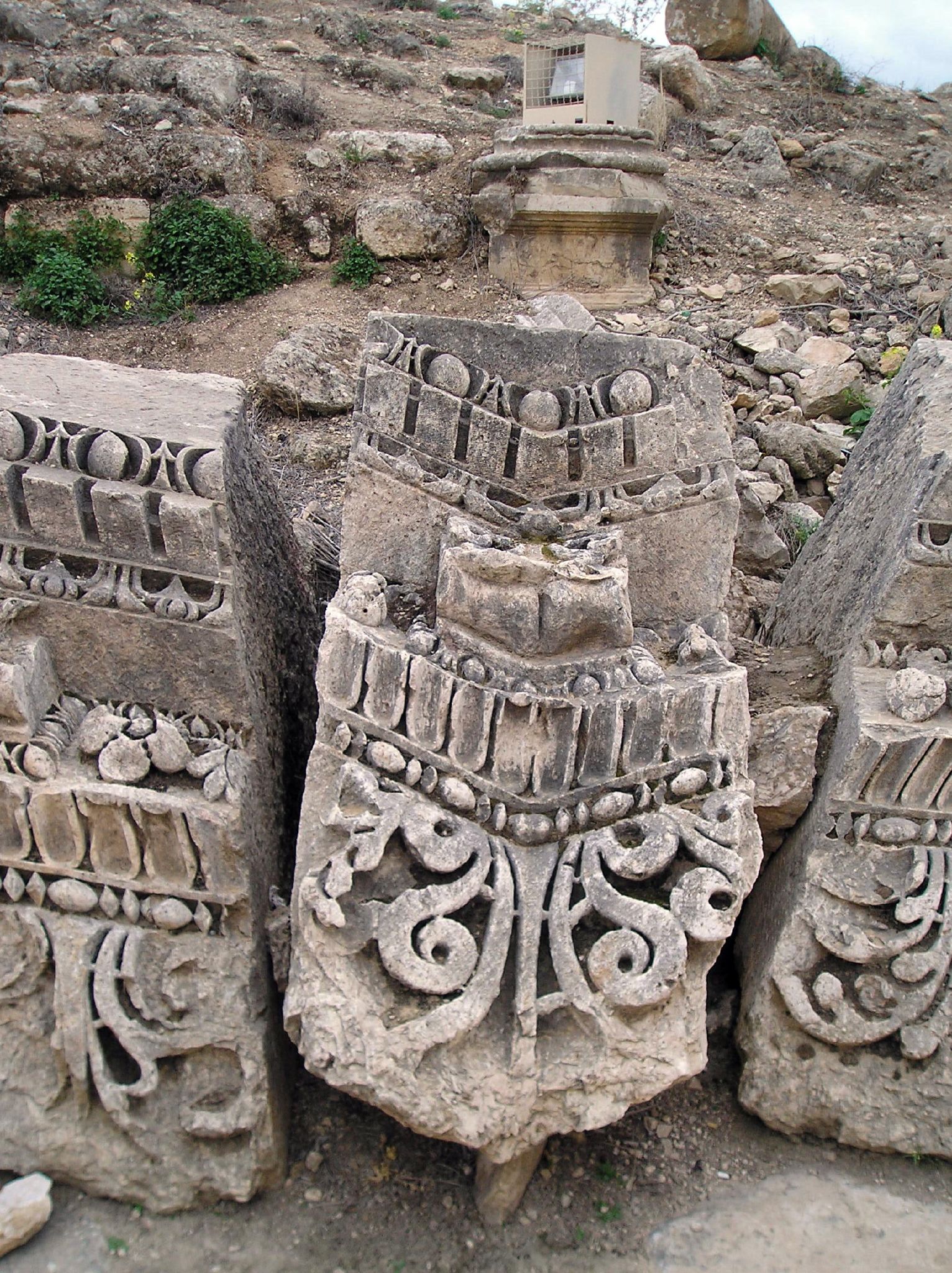 three ancient stone sculptures sitting on the side of a mountain