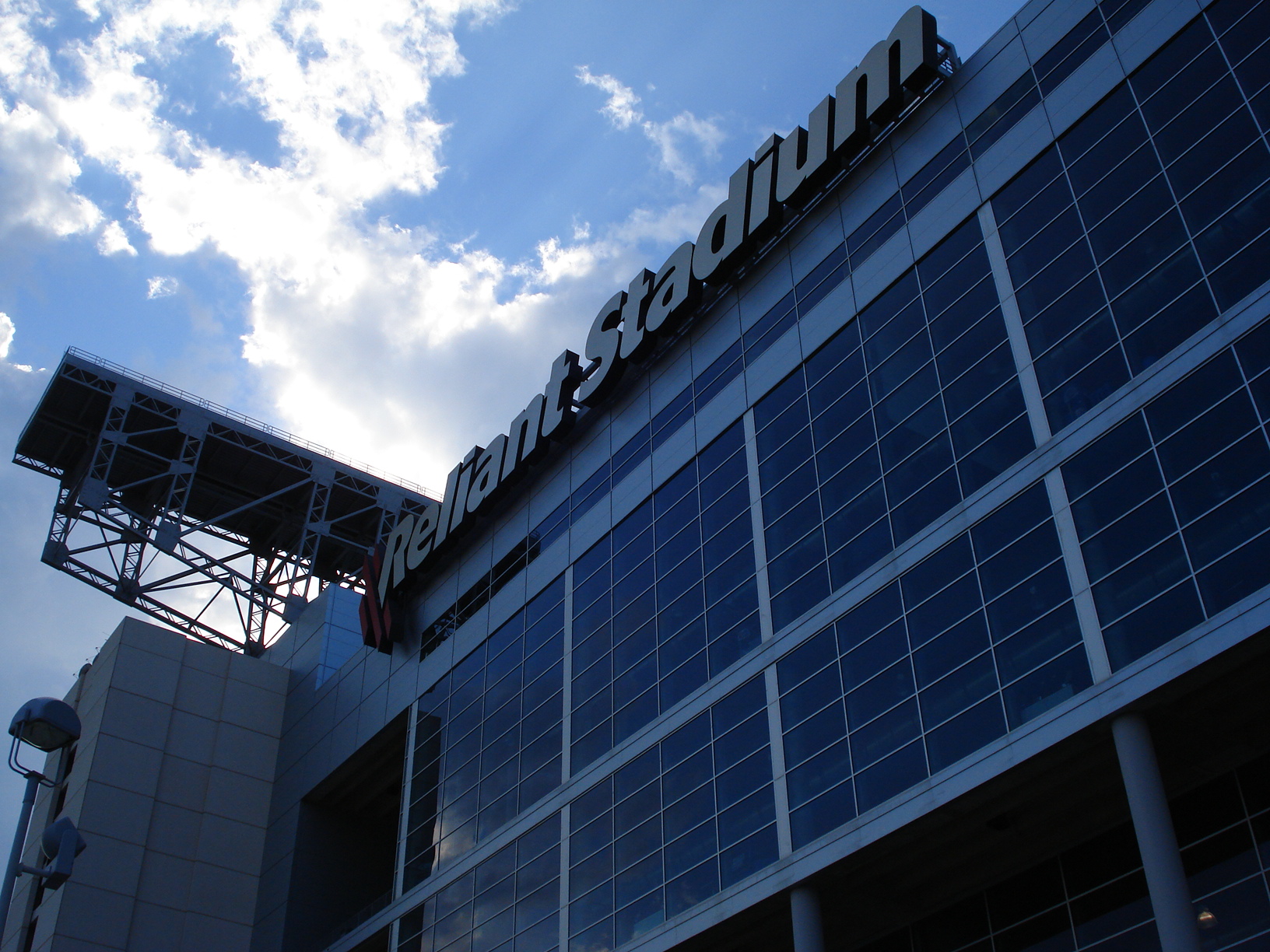 the stadium is blue and white as a blue sky surrounds it