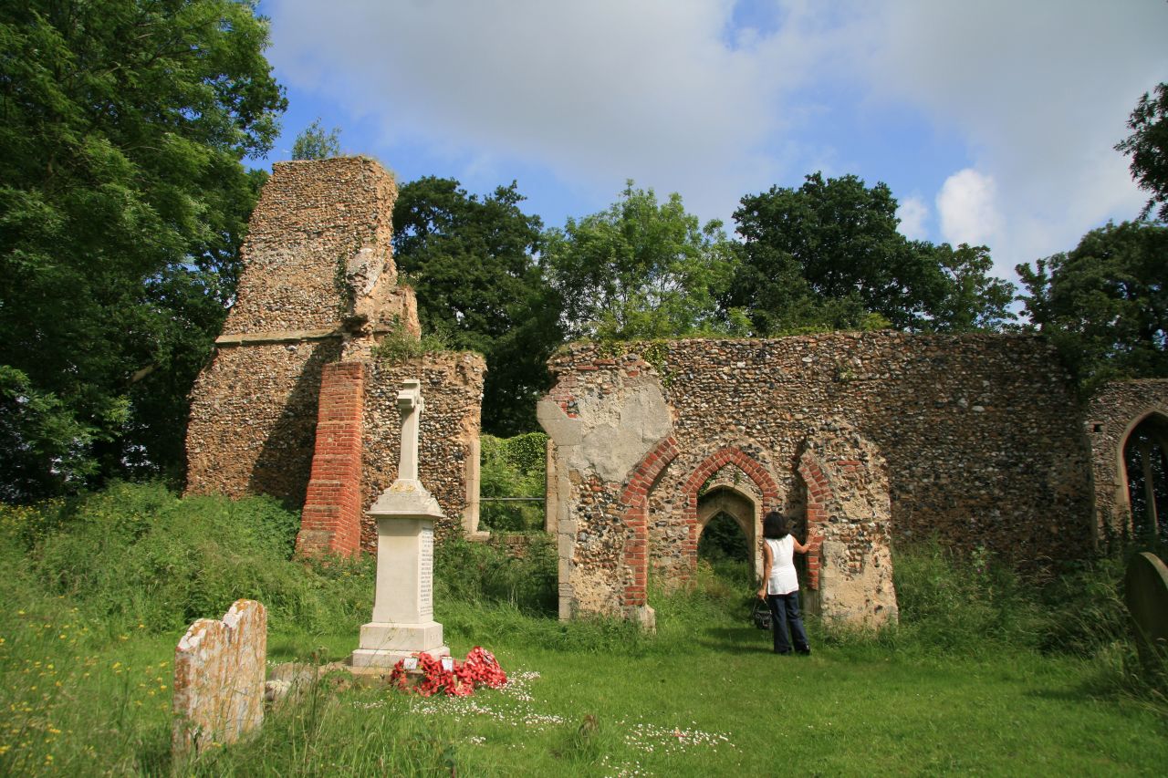 a guy standing near a monument and a very old building