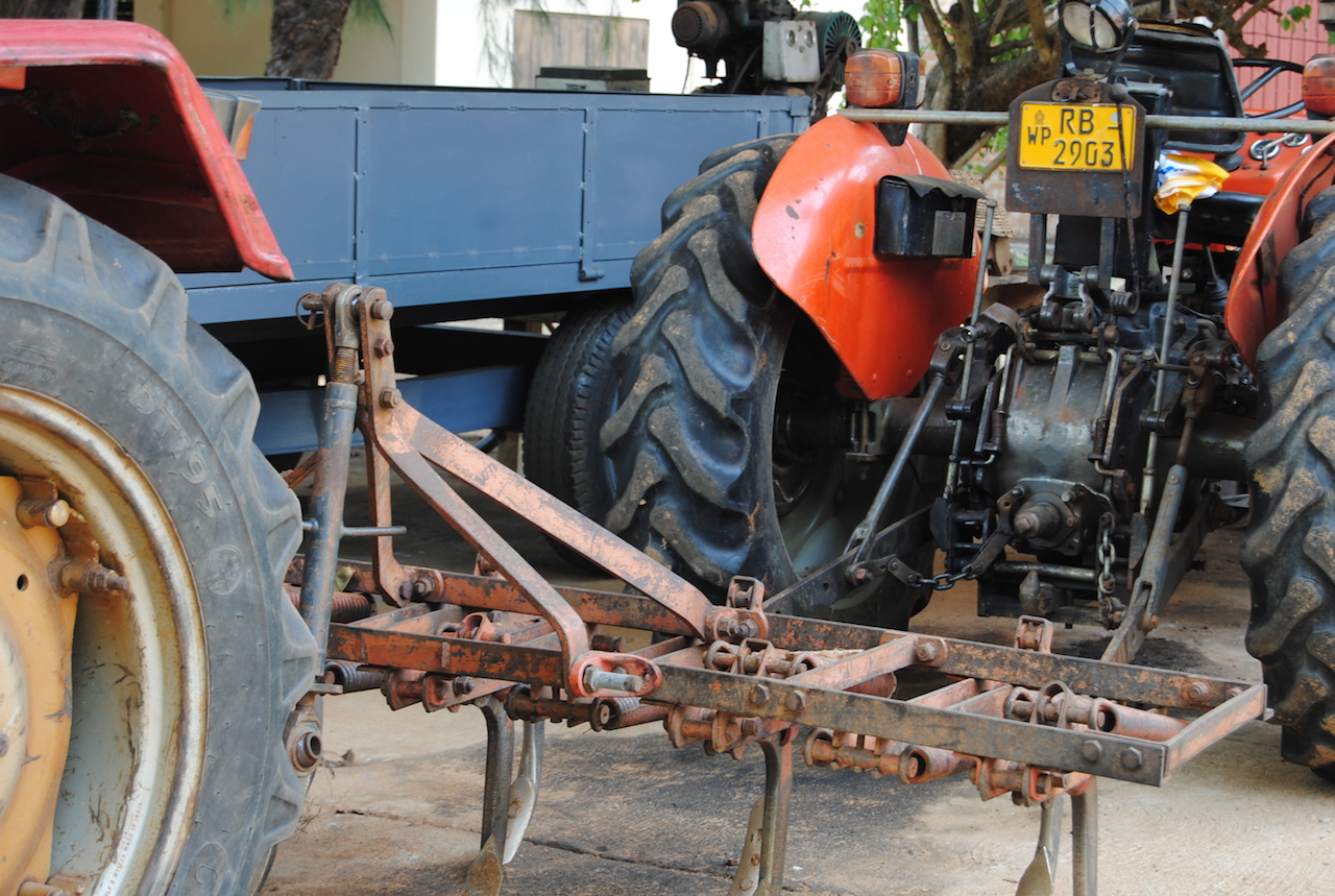 a large blue truck parked next to two big tractors