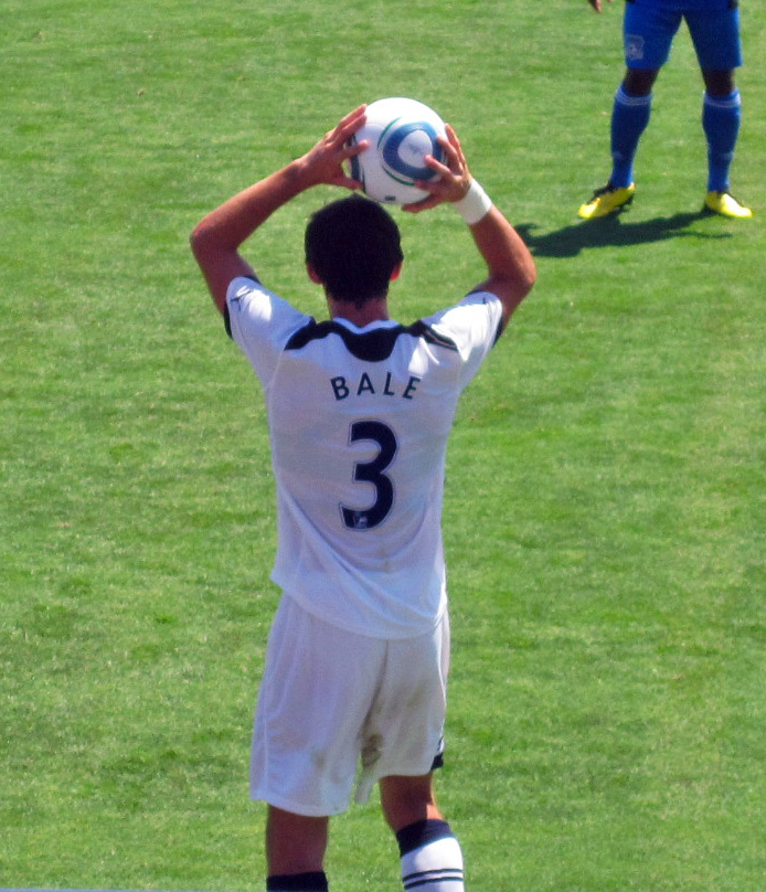 a male soccer player holds his head above his head