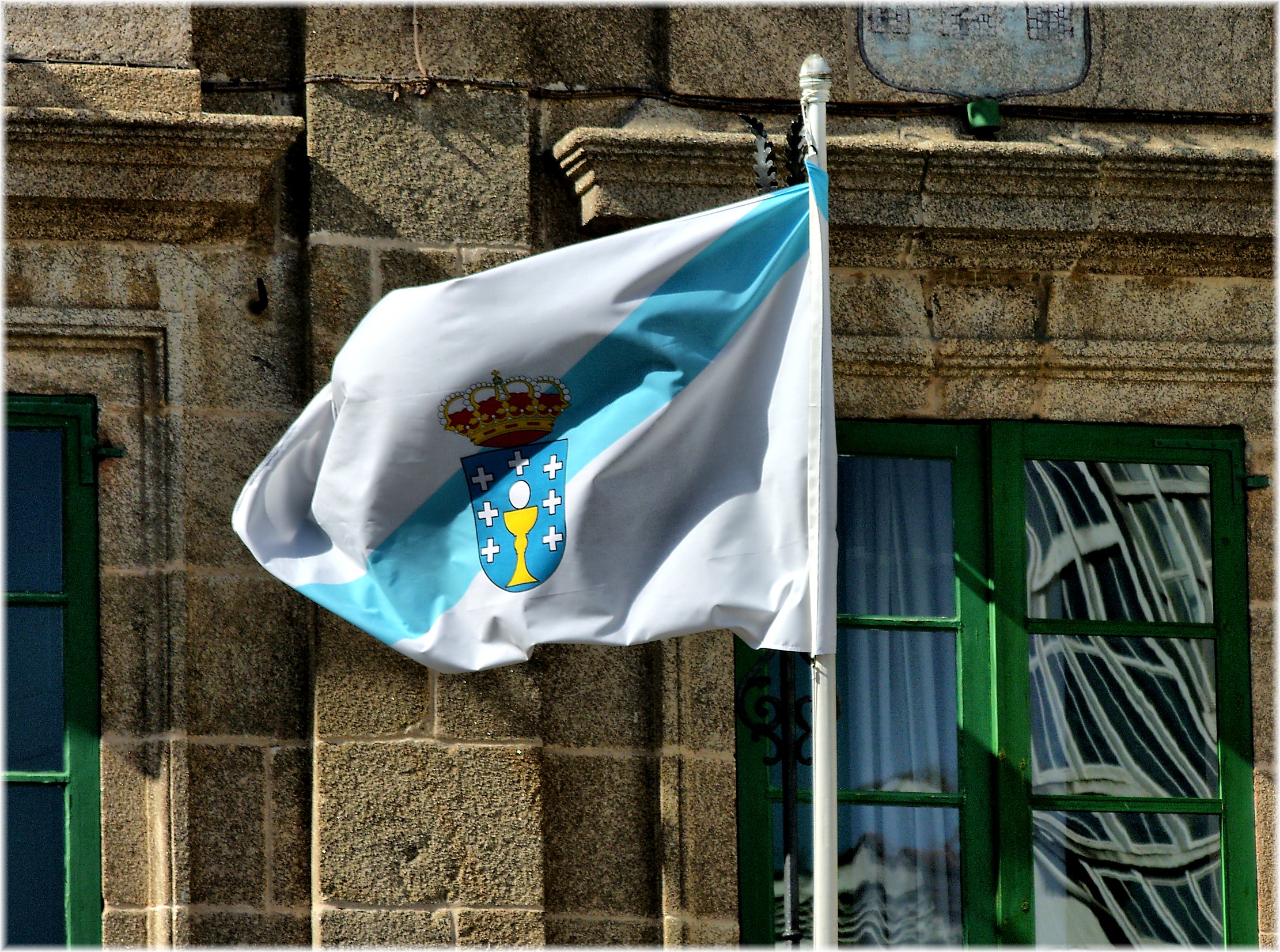 a flag flying outside of a building next to a green door