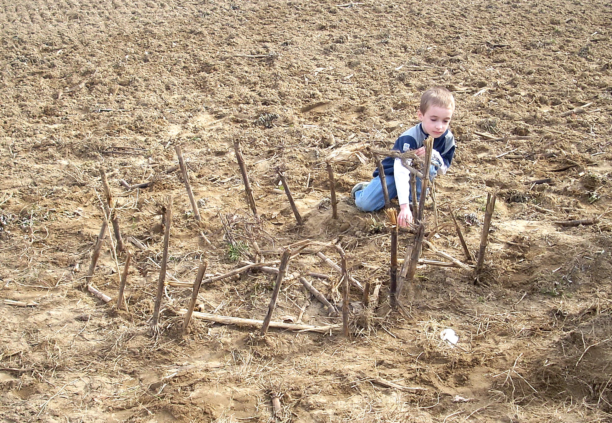 a young child kneeling down in the middle of a field