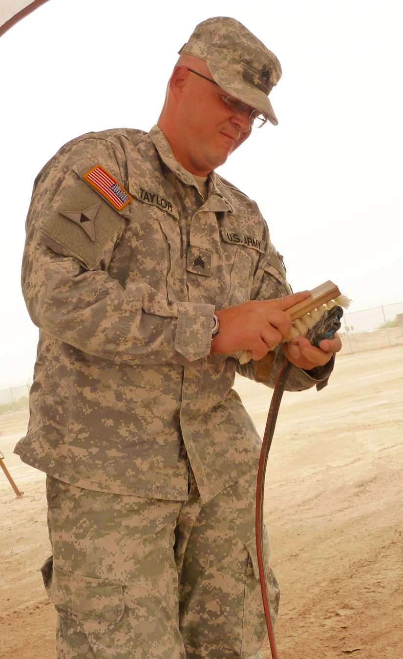 a male military person in fatigues holding soing