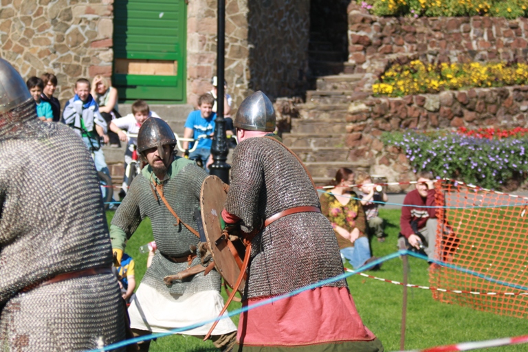 knights are standing near an obstacle course at a medieval event
