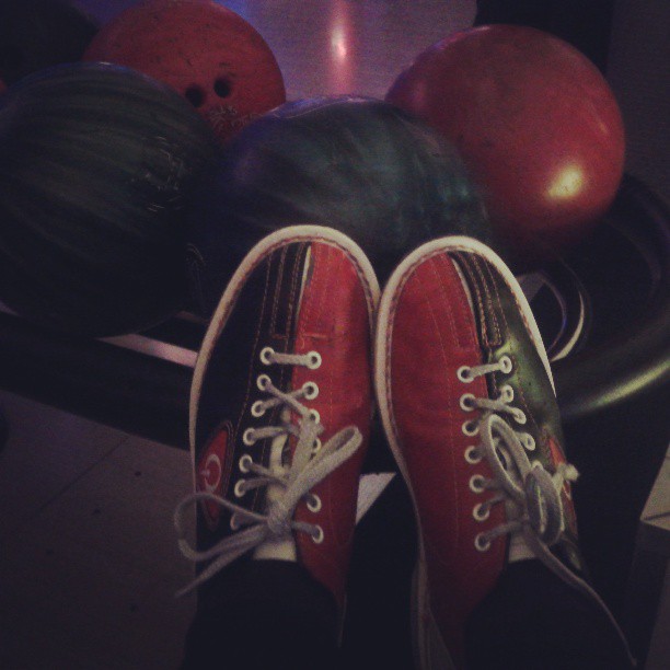 there are tennis shoes that are sitting on bowling balls