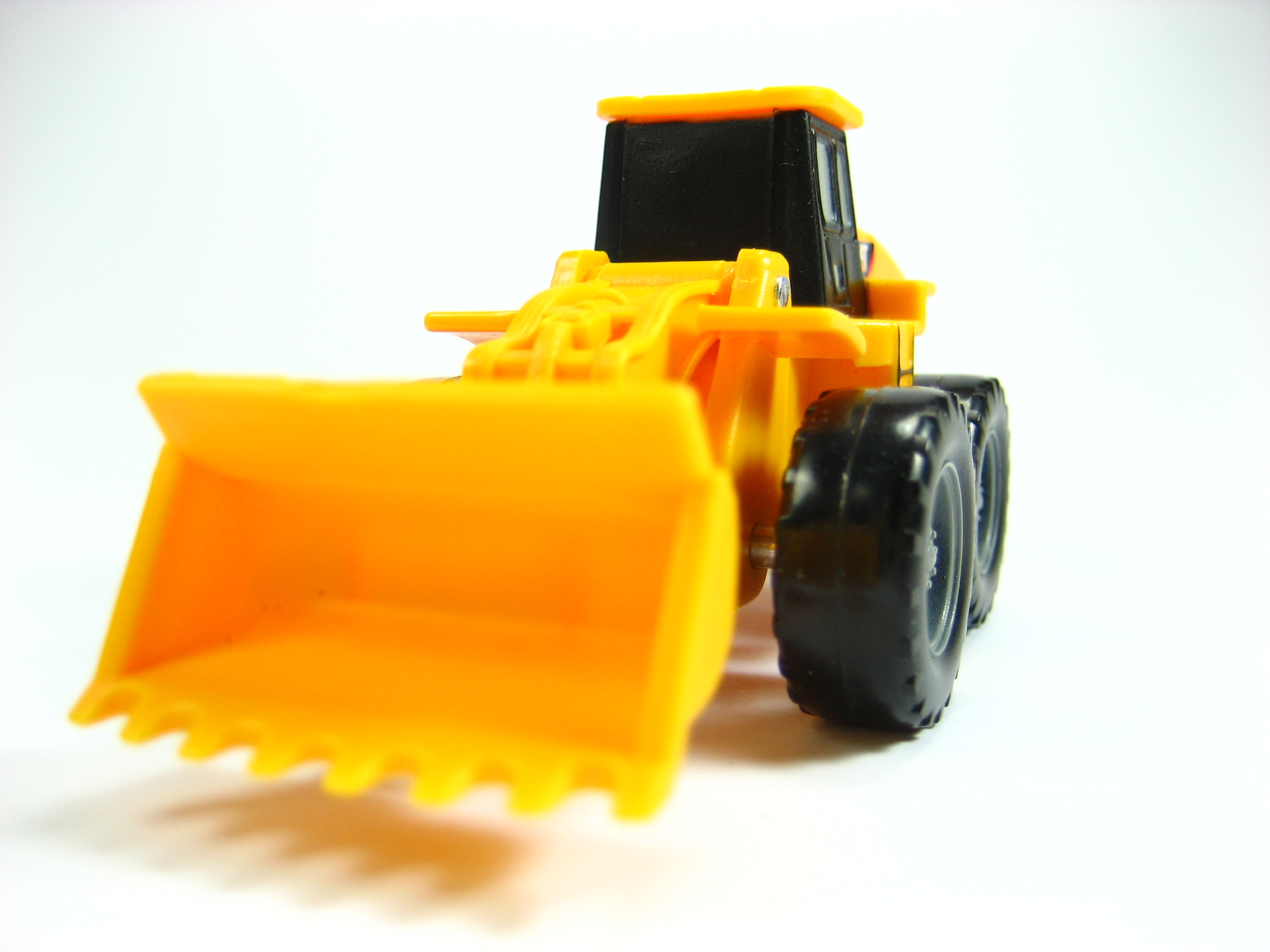 a plastic construction truck toy sitting up against a white background