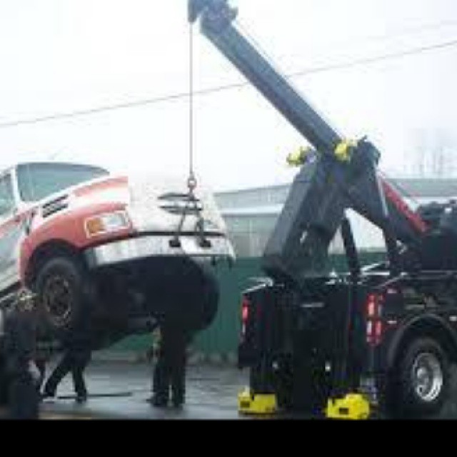a car being lifted by a crane onto a trailer