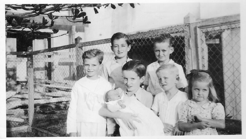 a family standing together in front of a fence