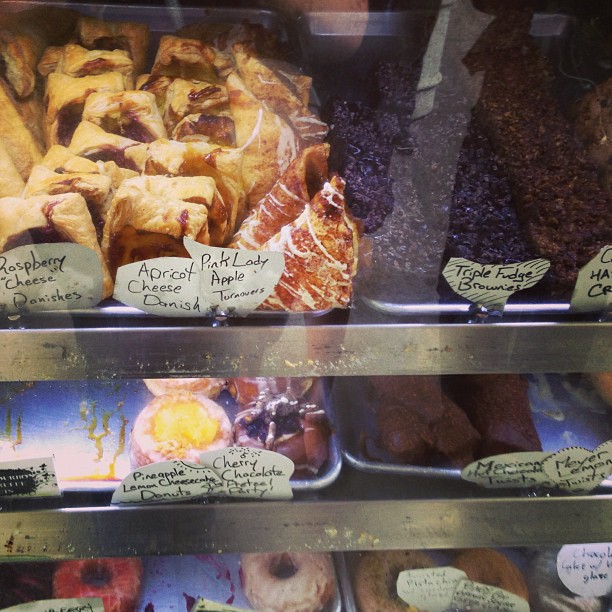 several dessert items sit on display behind glass