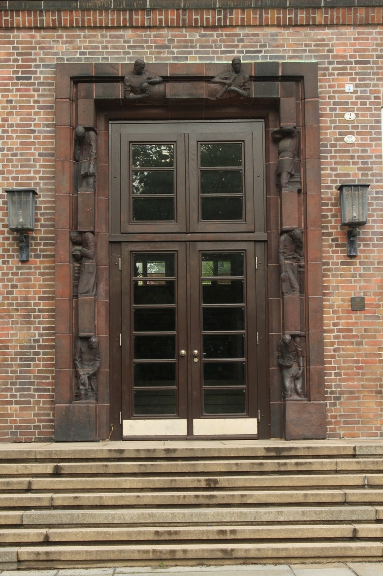two wooden doors sitting on the side of a building