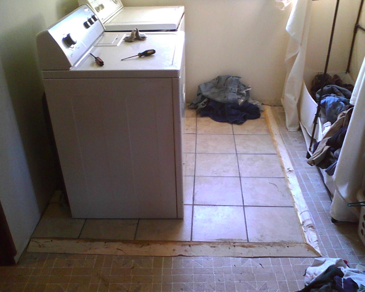 the interior of a dirty bathroom with a washing machine in it