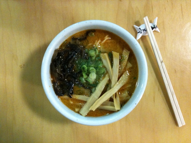 a bowl of ramen with black beans and broccoli