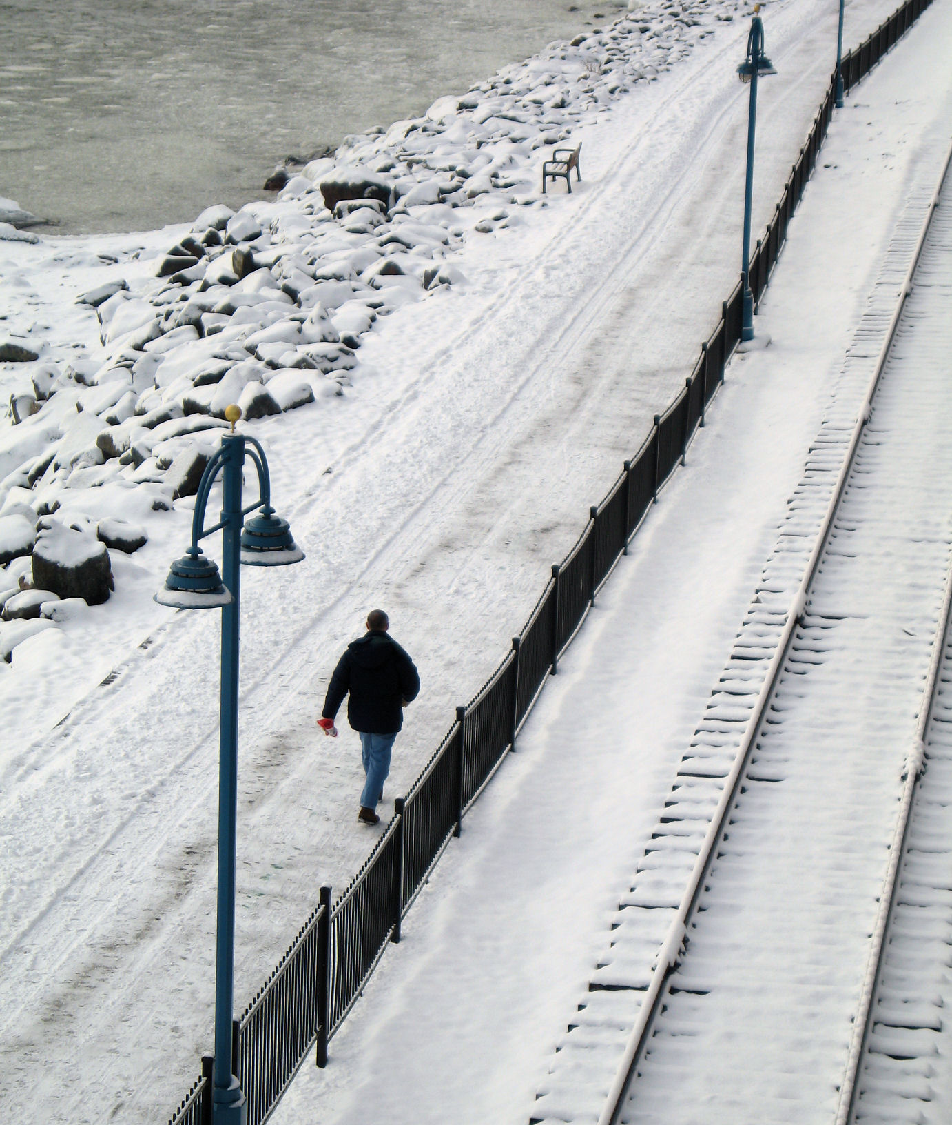 man walking along the tracks in the snow