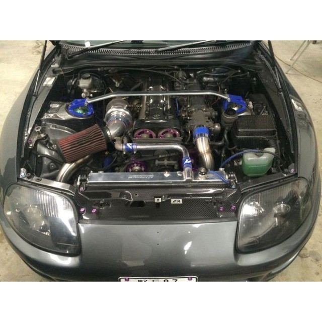 a car with an engine bay open and several parts inside