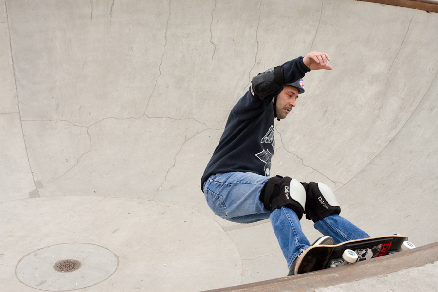 a skateboarder performing an aerial trick on the side of a ramp