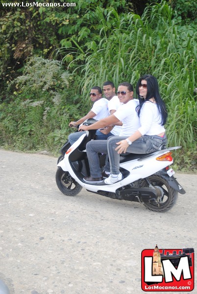 a group of people are riding on a motorbike