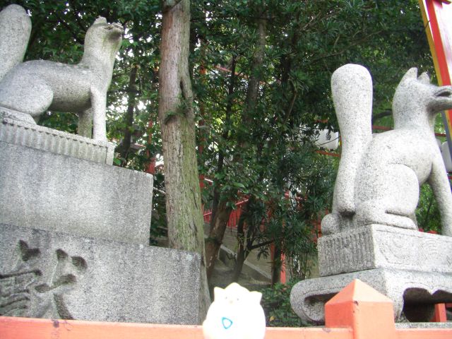 statues at the top of a wall in front of trees