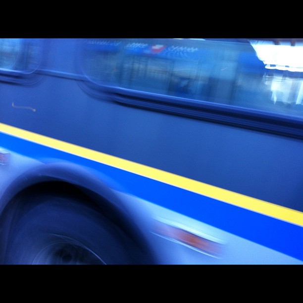 a blue bus with its door open is shown in motion