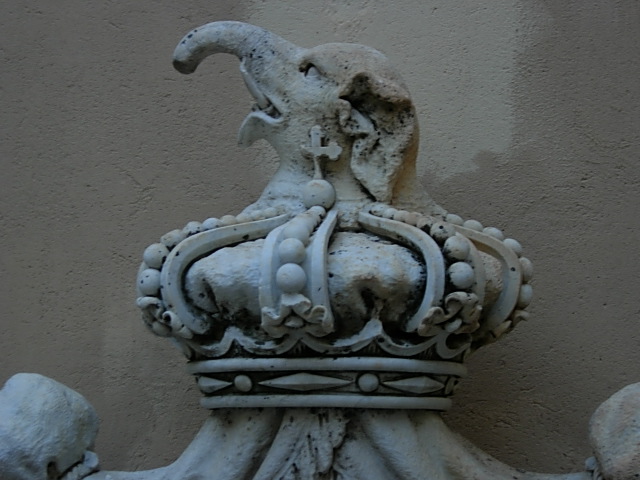 a statue in front of a stucco wall
