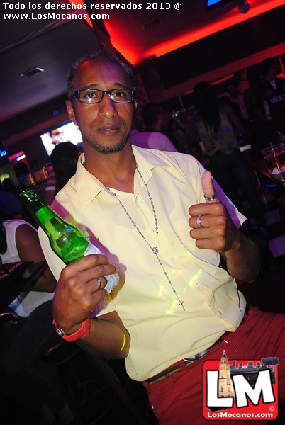 a man in white shirt holding up a green bottle